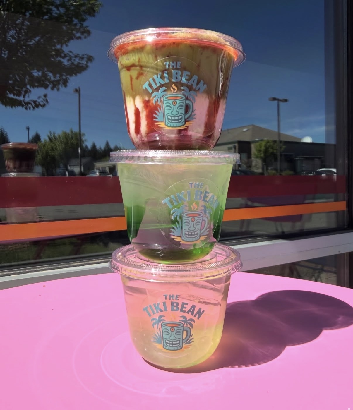 Stacked tropical refreshers glowing on a hot-pink table
